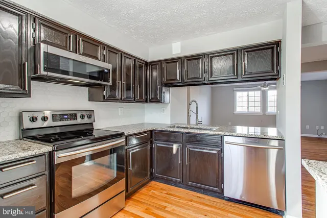 a kitchen with stainless steel appliances granite countertop a stove and a sink