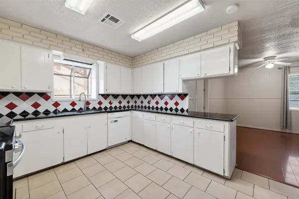 a kitchen with granite countertop cabinets and white appliances
