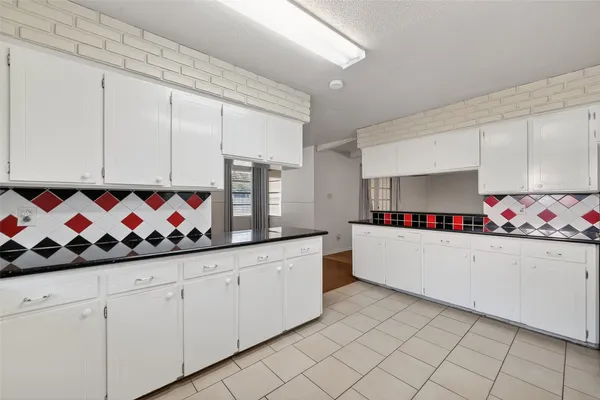 a kitchen with granite countertop white cabinets and sink