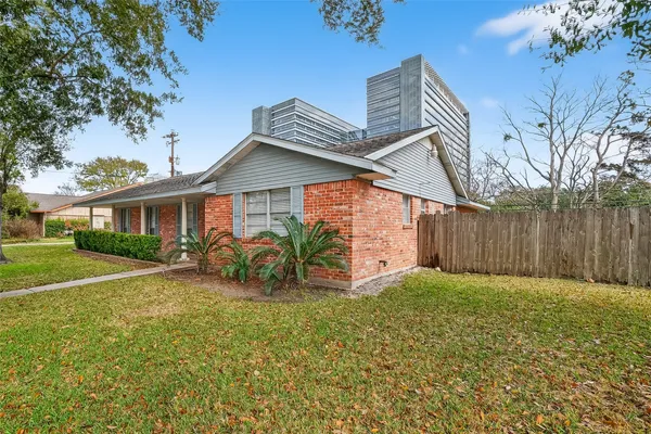 a view of a house with a yard and potted plants