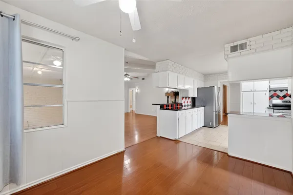 a large kitchen with cabinets and wooden floor