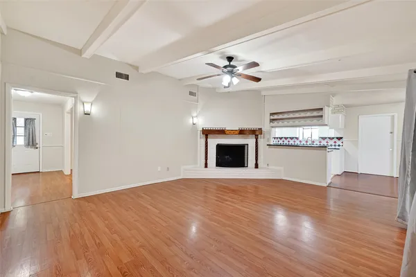 a view of an empty room with a fireplace and a window
