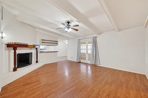 wooden floor fireplace and windows in an empty room
