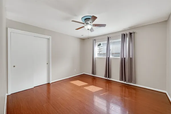 an empty room with closet and a ceiling fan