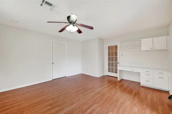 a view of empty room with wooden floor and window