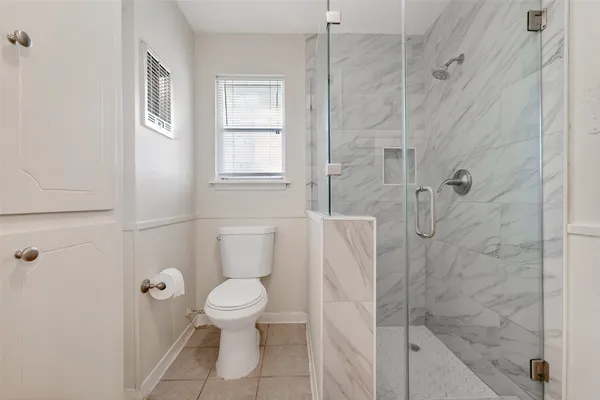 a bathroom with a toilet and a shower