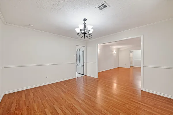 a view of a room with wooden floor and chandelier