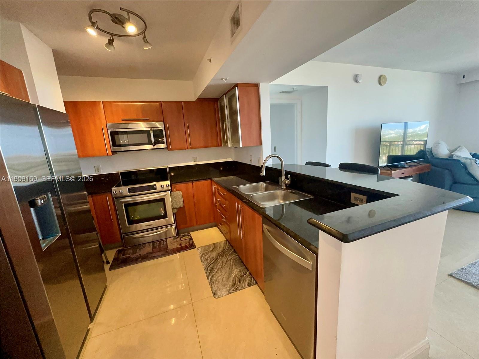 3232 Southwest 22nd Terrace, Unit 1604 Miami, FL 33145 - Photo 11 of 40 a kitchen with a sink a stove and chairs
