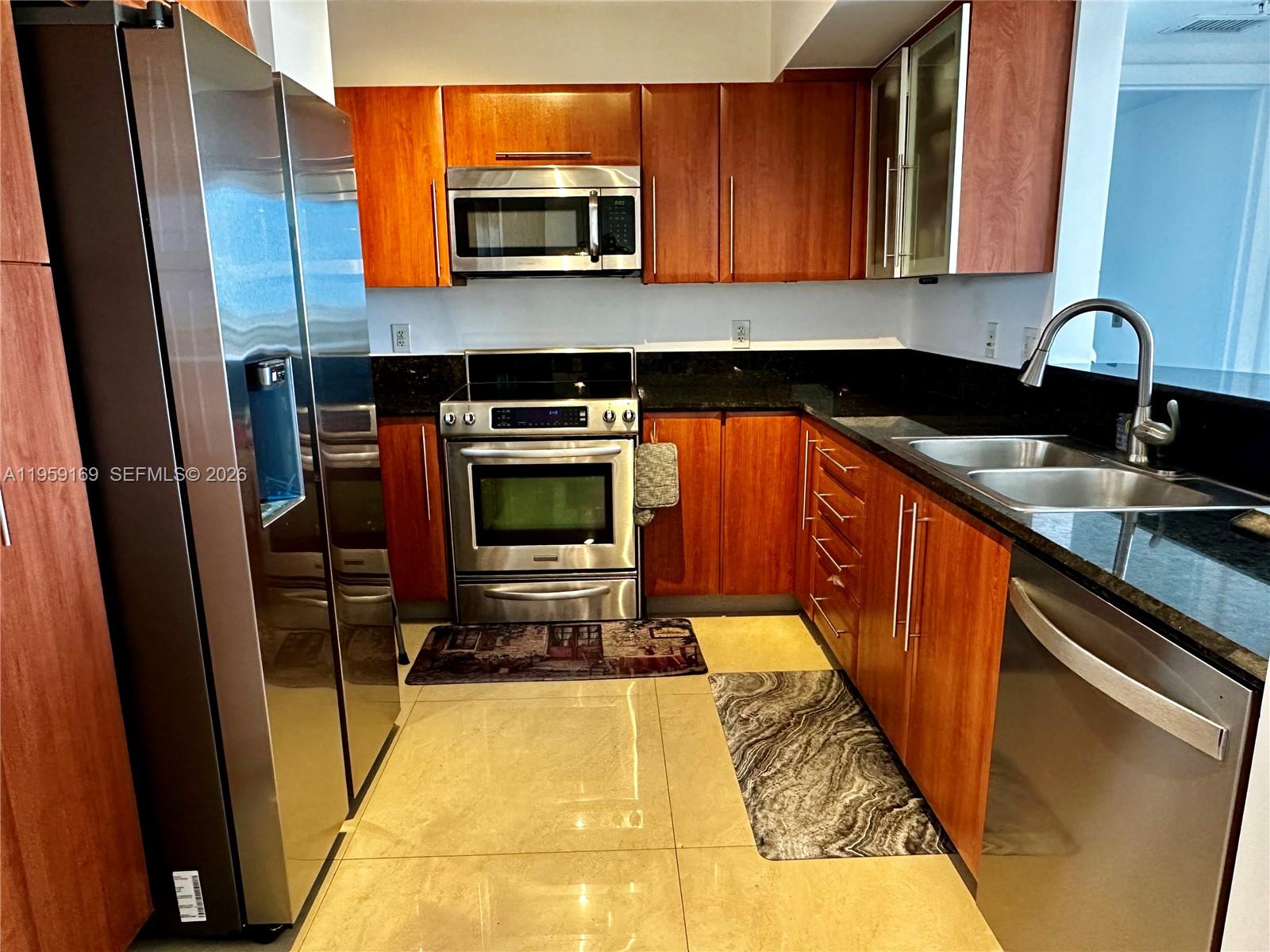 3232 Southwest 22nd Terrace, Unit 1604 Miami, FL 33145 - Photo 12 of 40 a kitchen with stainless steel appliances a stove a sink and a microwave