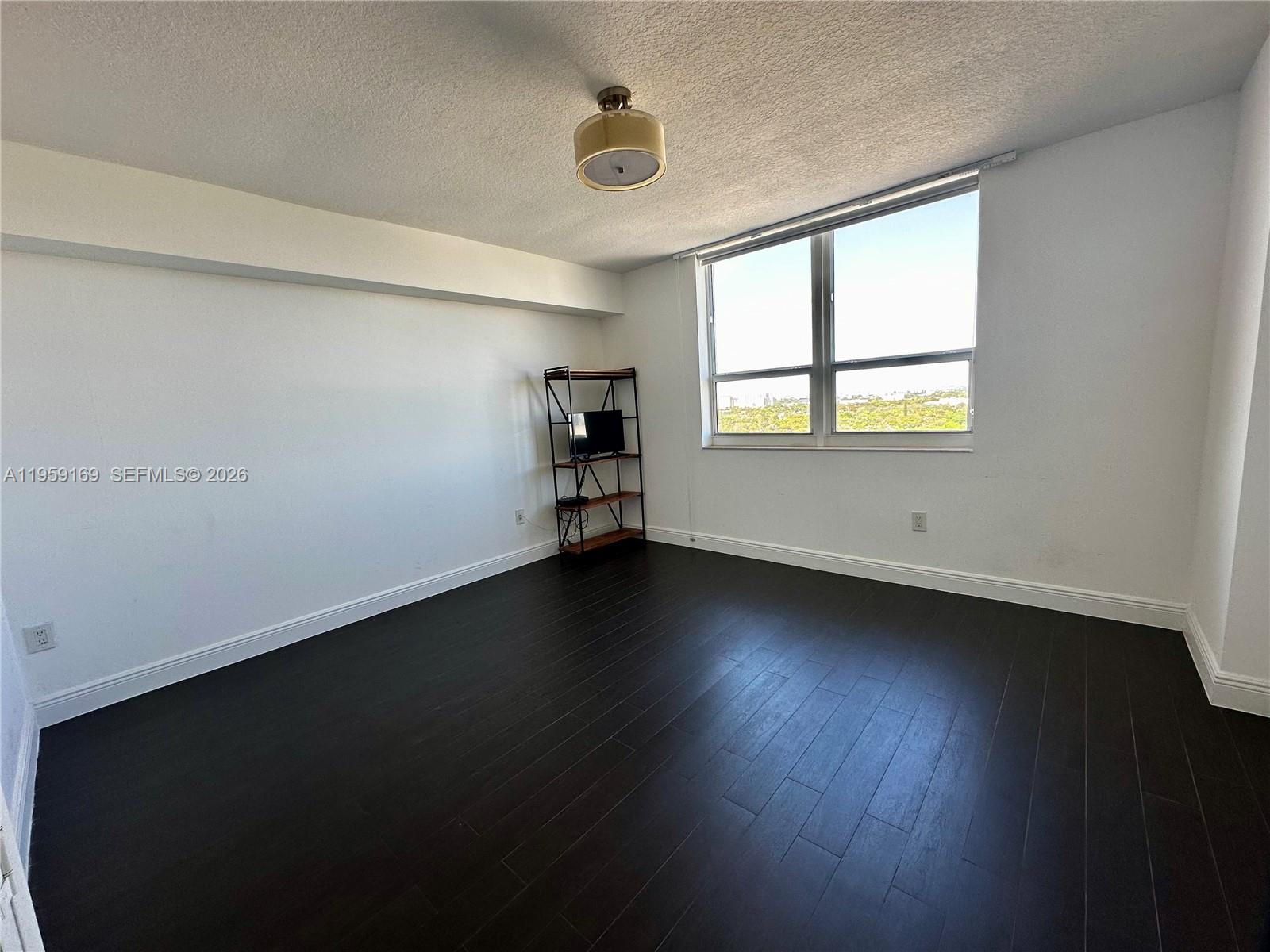 3232 Southwest 22nd Terrace, Unit 1604 Miami, FL 33145 - Photo 20 of 40 an empty room with wooden floor and windows