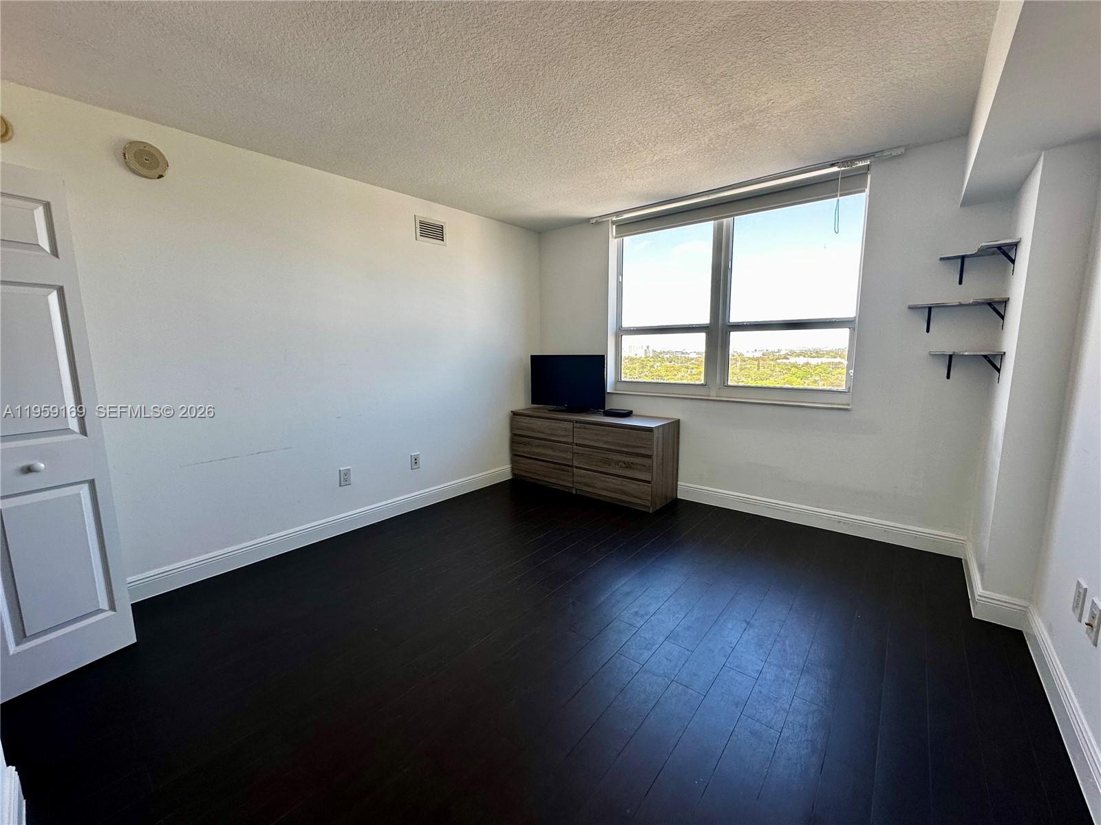 3232 Southwest 22nd Terrace, Unit 1604 Miami, FL 33145 - Photo 27 of 40 a view of a room with wooden floor and a window