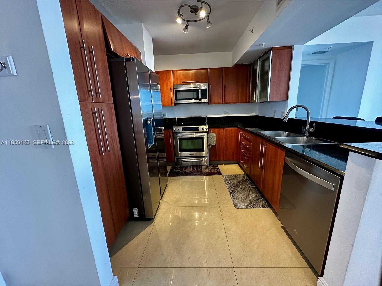 3232 Southwest 22nd Terrace, Unit 1604 Miami, FL 33145 - Photo 10 of 40 a kitchen with stainless steel appliances granite countertop a stove and a sink