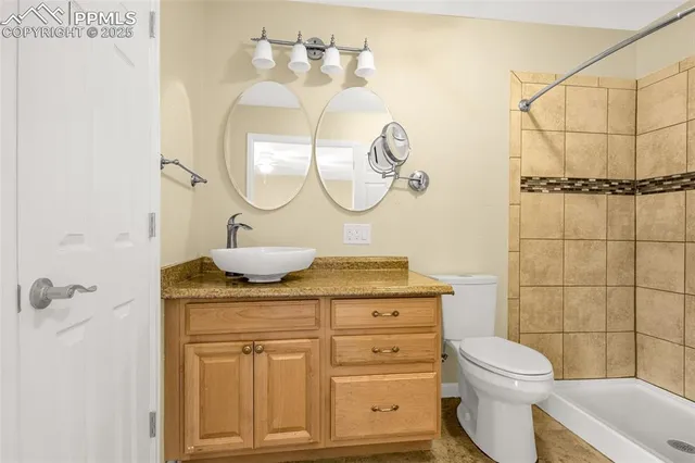 a bathroom with a granite countertop toilet sink and mirror