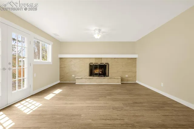 a view of empty room with wooden floor and fireplace