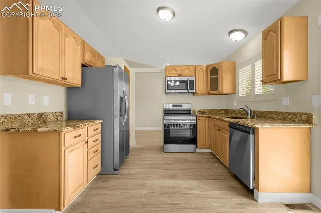 a kitchen with stainless steel appliances granite countertop a refrigerator and a stove top oven