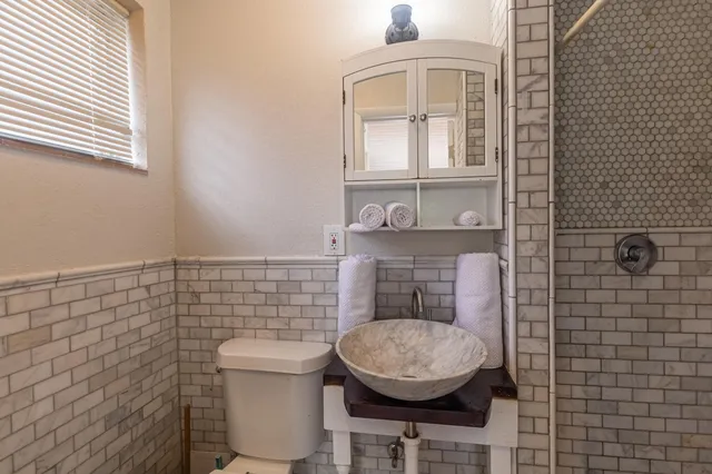 a bathroom with a toilet a sink and mirror
