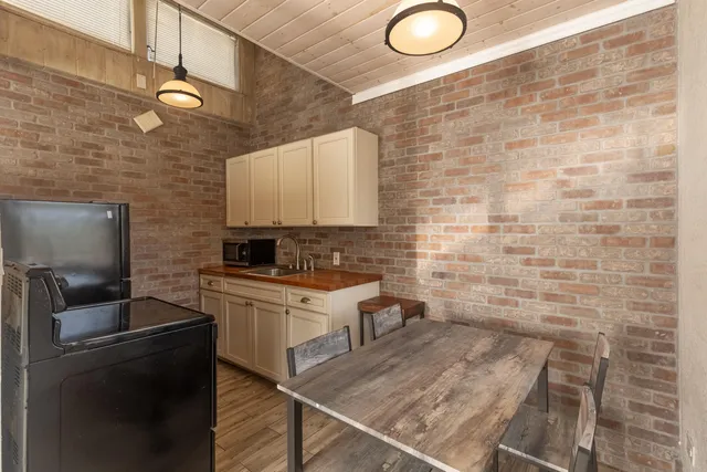 a kitchen with a sink a stove cabinets and a dining table