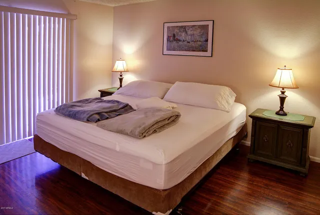 a bed sitting in a bedroom next to a lamp