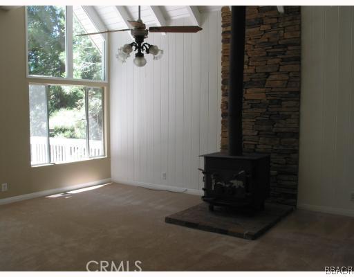 690 Rhine Road Lake Arrowhead, CA 92352 - Photo 4 of 8 a living room with a fireplace and a window