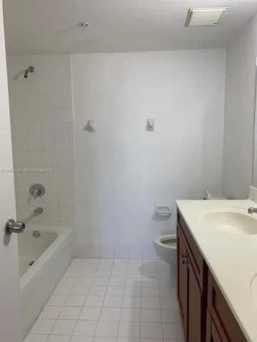a bathroom with a granite countertop sink a toilet and bathtub