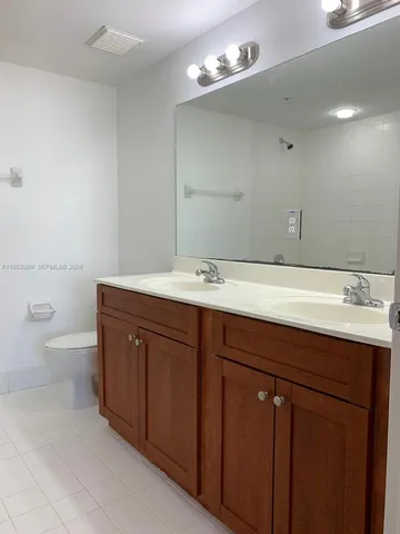 a bathroom with a sink a toilet and a mirror