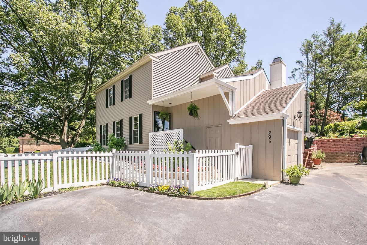 295 Sugartown Road Wayne, PA 19087 - Photo 2 of 36 a view of a white house that has a small yard and wooden fence