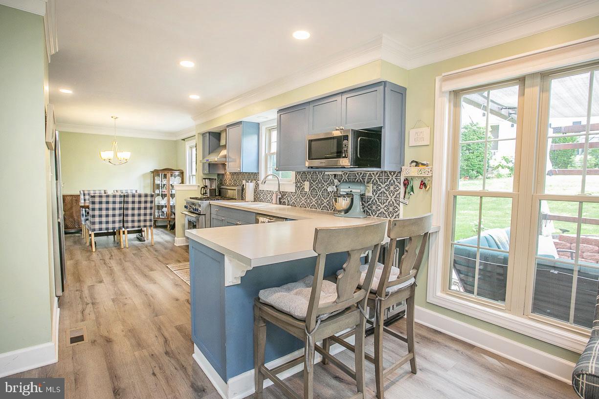 295 Sugartown Road Wayne, PA 19087 - Photo 13 of 36 a dining hall with stainless steel appliances granite countertop a kitchen island hardwood floor and a sink
