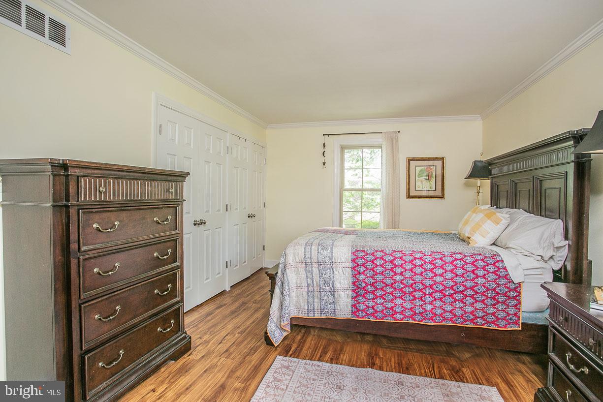 295 Sugartown Road Wayne, PA 19087 - Photo 19 of 36 a bedroom with a bed and wooden floor