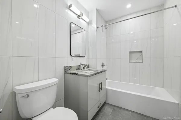 a bathroom with a granite countertop sink a toilet and shower