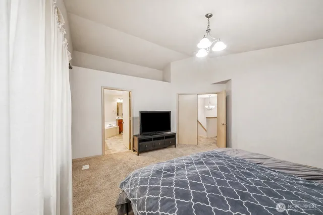 a bedroom with a bed and a flat tv screen on dresser