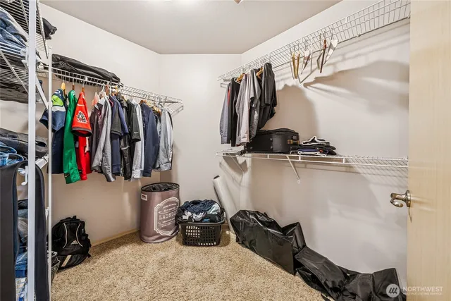 a view of walk in closet with clothes and shoes