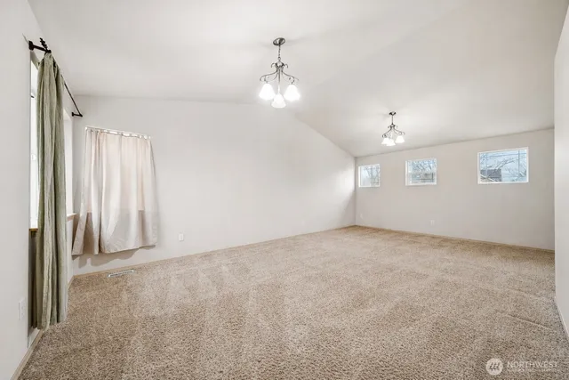 an empty room with windows and ceiling fan