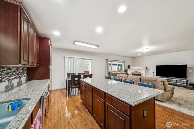 a kitchen with a stove a sink a microwave a dining table and chairs