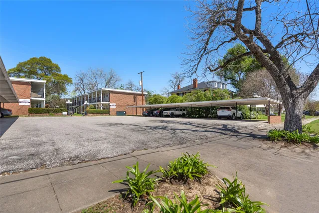 a street view with flower plants and wooden fence