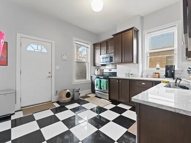 a kitchen with a checkered floor and white cabinets
