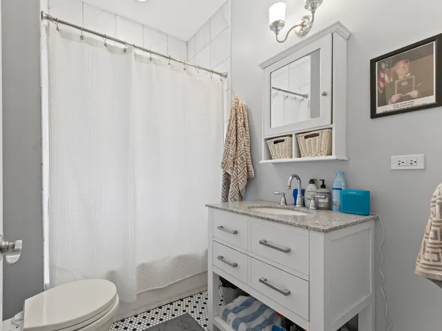 a bathroom with a granite countertop sink toilet and shower