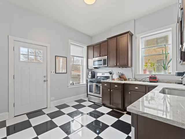 a large kitchen with a checkered floor and white cabinets