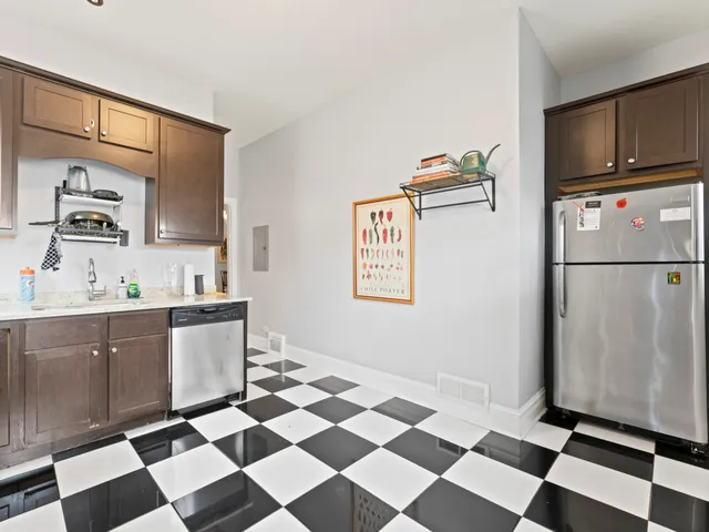 a kitchen with a checkered floor and white cabinets