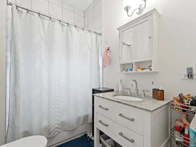 a bathroom with a sink a toilet and shower curtain