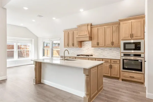 a kitchen with stainless steel appliances granite countertop a sink and cabinets