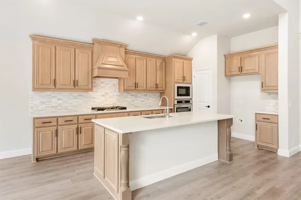 a kitchen with stainless steel appliances granite countertop a stove a sink and white cabinets