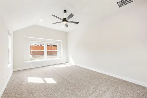 an empty room with a window and a fan