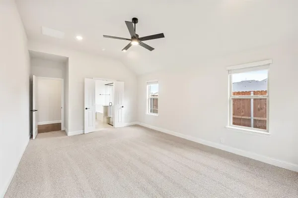a view of empty room with windows and ceiling fan