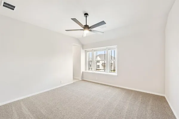 an empty room with a window and a fan