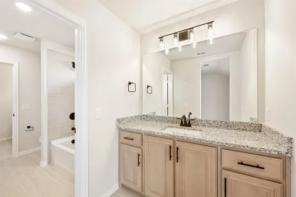 a bathroom with a granite countertop sink and a mirror