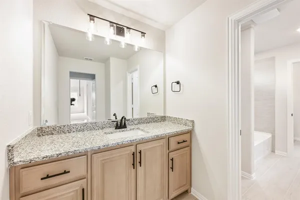 a bathroom with a granite countertop double vanity sink and a mirror