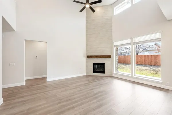a view of an empty room with a fireplace and a window