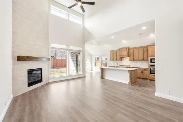 a large kitchen with cabinets wooden floor and a fireplace