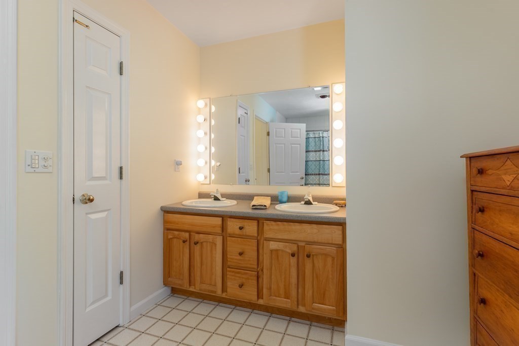82 Nashoba Road Littleton, MA 01460 - Photo 22 of 39 a bathroom with a granite countertop sink a mirror and a shower