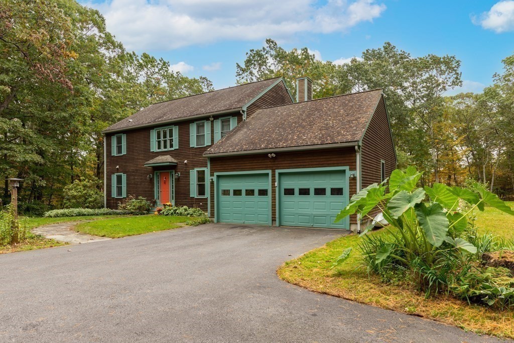 82 Nashoba Road Littleton, MA 01460 - Photo 23 of 39 a front view of a house with a yard and garage